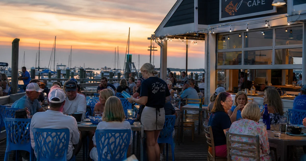 A coastal NC restaurant patio during a busy summer dinner service with ocean view